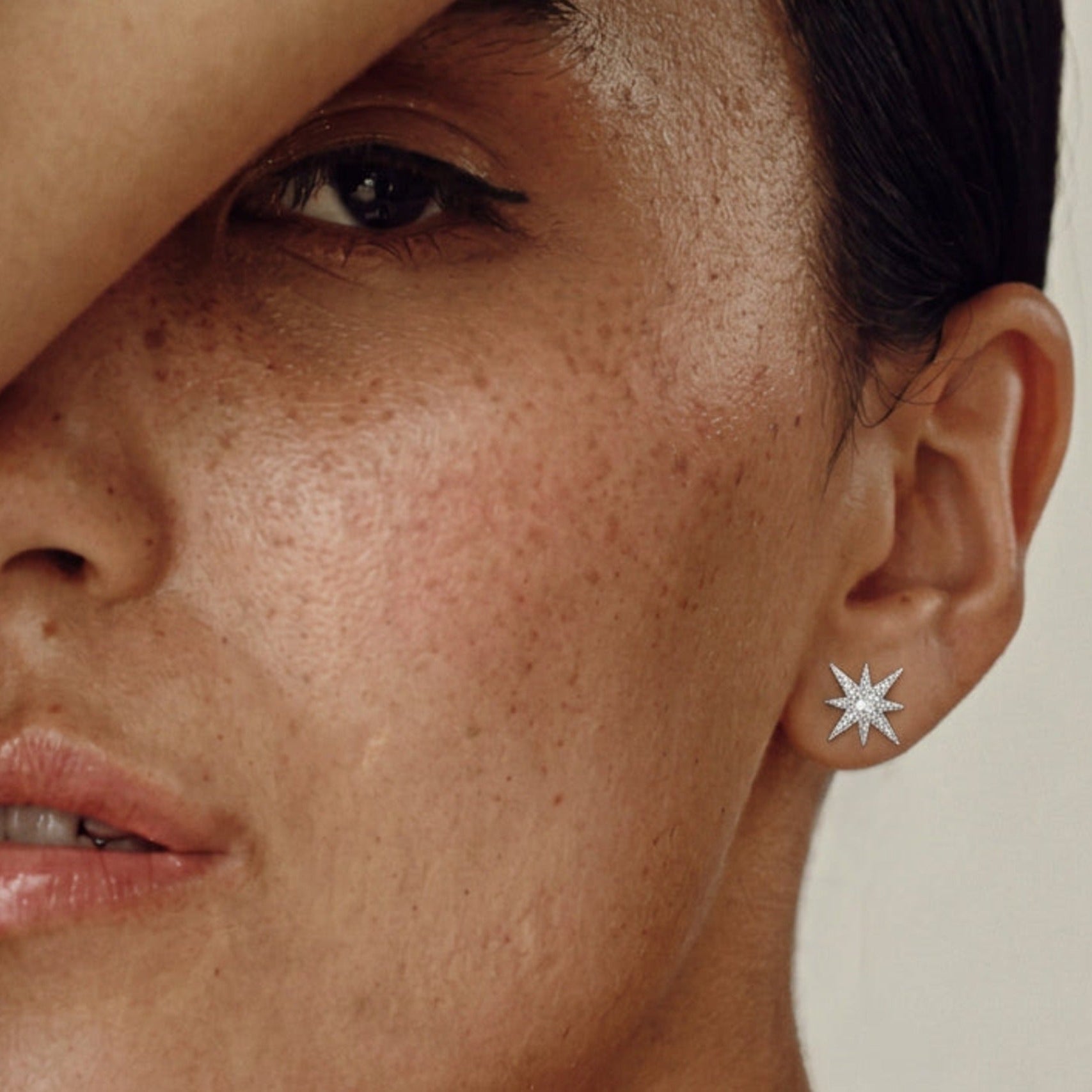 Close-up of a Tara Star Stud Earring worn in the ear